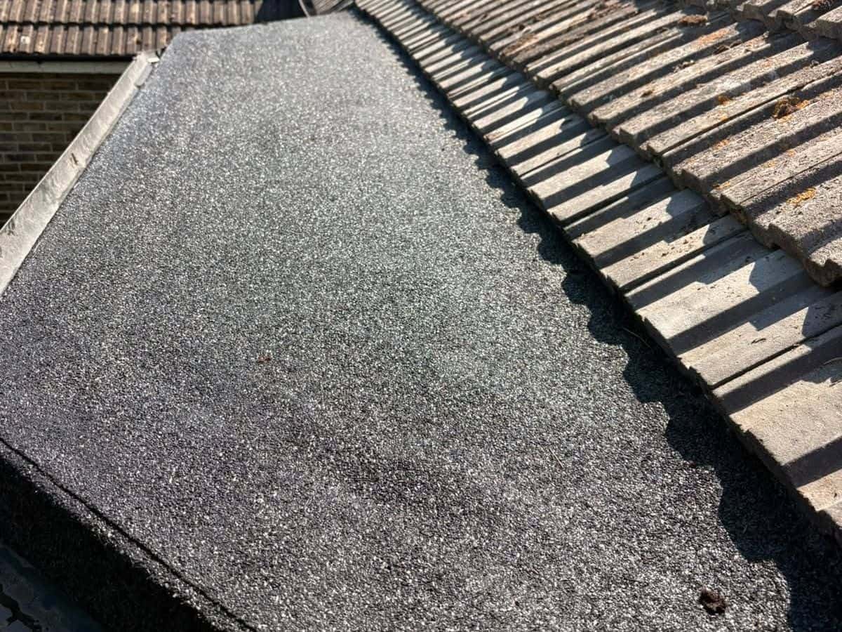 New mineral felt flat roof next to a tiled roof